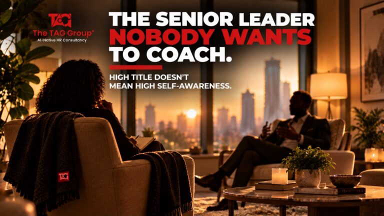 Two people in armchairs in a warmly lit room at sunset, one taking notes while the other talks, headlined 'The senior leader nobody wants to coach. High title doesn't mean high self-awareness.'